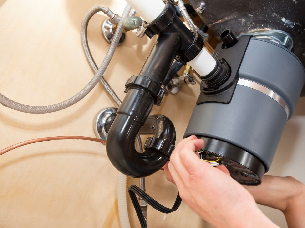 Plumber repairing garbage disposal